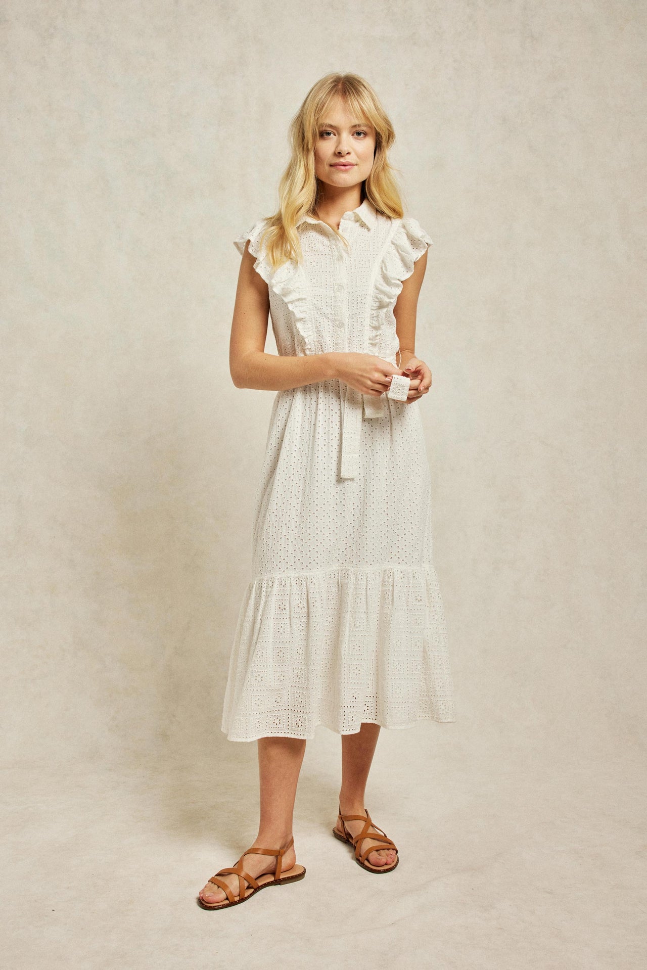 The Crocus features ruffles which trim the design, cut from traditional broderie anglaise and fitted with a self-tie waist. Smart casual wear. Summer dress. Size 6,8,10,12,14,16,18. Machine wash.